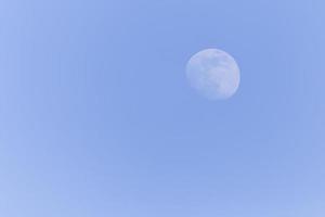 view on waxing gibbous Moon in a blue sky photo