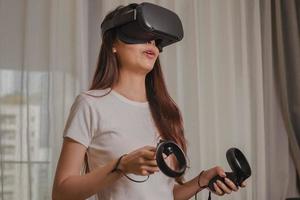 felicidad asiático joven mujer vistiendo vr auriculares o visual realidad gafas de protección, lentes o artilugio. niña jugar videojuego de simulador futuro, futurista mientras usable. tecnología de moderno concepto. foto