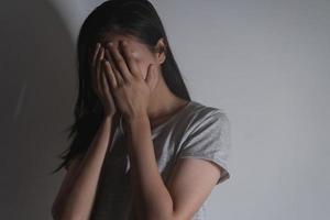Mental health, depressed sad asian young woman, girl cover her face with hand, expression to face difficulty, failure and exhausted. Thoughtful worried suffering depression feeling lonely, alone. photo