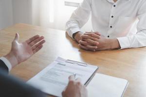 Asian young manager, employer man interview with person, have question about resume and listen to candidate answer, conversation together at office. Recruitment employee job concept. photo