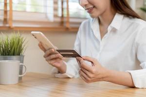 Online internet banking, asian young woman hand in payment spending by scan qr code, use phone, mobile to transfer money or pay money of credit card without cash at home. Technology of financial. photo