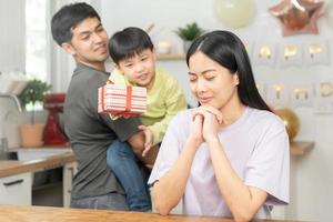 aniversario, contento cumpleaños fiesta en familia, asiático joven padre padre o papá, madre o mamá y pequeño linda chico o niño celebrando dar regalo, presente, sorpresa celebracion a hogar. encantador momento. foto