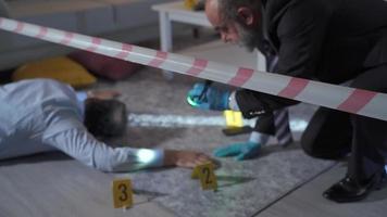 Police conducting forensic investigations of the victim killed in the apartment. Forensic Crime Police Inspector collects evidence and examines forensic evidence video