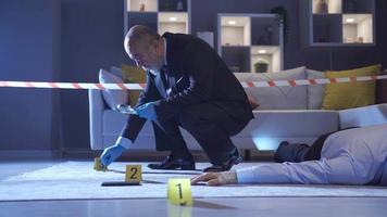 The police are examining the evidence. Crime scene Investigation. Police man conducting a murder investigation examines evidence at the crime scene.
