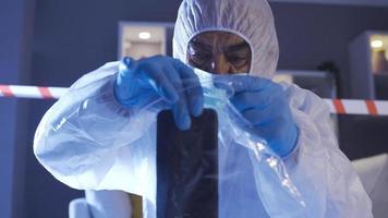 The forensic specialist does the criminal work at the crime scene. Forensic expert who carefully puts forensic evidence in plastic bags. video