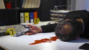 The businessman committed suicide in his office. Criminal scene. Mature businessman committed suicide by shooting himself in the head with a gun in his office. video