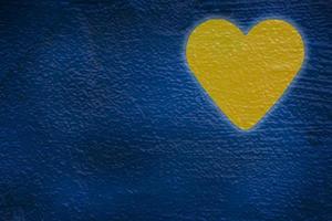 yellow heart painted on blue wall photo