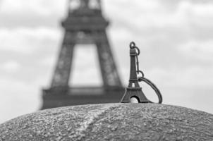 Eiffel tower keychain against real Eiffel tower photo