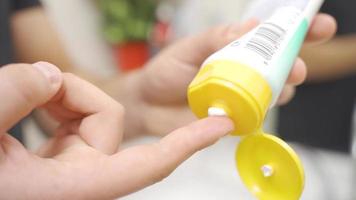 Face cream. Applying cream to the skin. In the bathroom, male hand squeezes cream on his finger and rubs it on his skin. video