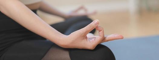 Workout, calm asian young woman, girl hand in calm pose sitting practice meditating in lotus position on mat at home, meditation, exercise for wellbeing, healthy care. Relaxation, happy leisure. photo