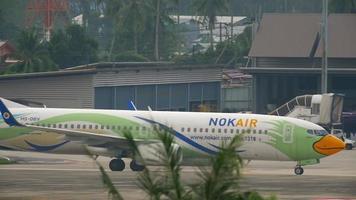 phuket, tailândia, 1 de dezembro de 2016 - nok air boeing 737 hs dbv taxiando após o pouso. vista do último andar do hotel centara grand west sands resort phuket video