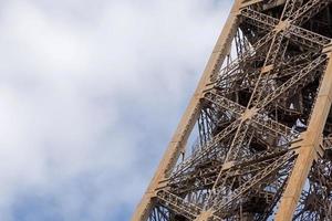 detail of Eiffel tower against cloudy sky photo