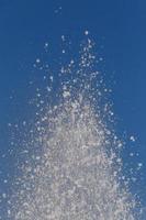 chapoteo de agua en fuente en contra azul cielo foto