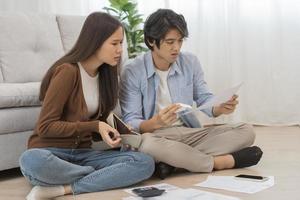 estresado financiero deber asiático joven Pareja amor sentado sufrir, estresado y confuso por calcular gastos desde factura o factura, No dinero a pagar, hipoteca o préstamo. deuda, arruinado o bancarrota gente. foto