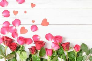 red and pink rose with paper heart on white wood background photo