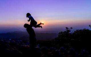 contento padre y hija disfrutando en puesta de sol fondo