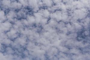 blanco hinchado nubes en un azul cielo foto