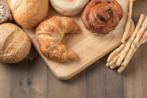 Homemade croissant and bread on old wood photo