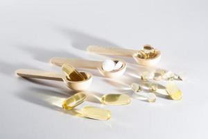 Spoons with vitamins, Vitamin D, omega 3, omega 6, Food supplement oil filled fish oil, vitamin A, vitamin E, flaxseed oil photo