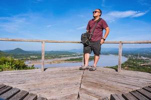 asiático grasa chico con hermosa paisaje ver en phu lamduan a loei tailandia.phu lamduan es un nuevo turista atracción y punto de vista de mekong río Entre Tailandia y loas. foto