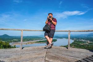 asiático grasa chico con hermosa paisaje ver en phu lamduan a loei tailandia.phu lamduan es un nuevo turista atracción y punto de vista de mekong río Entre Tailandia y loas. foto