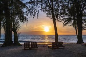 Wooden chair beside the beach with beautiful idyllic seascape sunset view on kohkood island.Koh Kood, also known as Ko Kut, is an island in the Gulf of Thailand photo