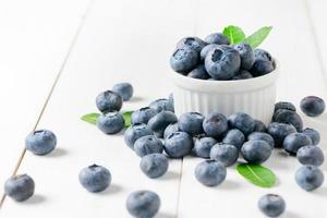 fresh blueberry fruits with leaf on white glass photo