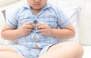 obeso grasa chico exceso de peso. apretado camisa de pijama foto