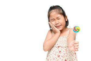 girl suffering from toothache and holding candy photo