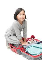 linda asiático niña embalaje maletas preparando para viaje viaje aislado foto