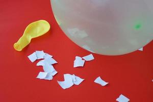 Science experiment about static electricity from balloon and pieces of paper. Red background. Concept, education, science subject. Teaching aid materials. Easy experiment. photo