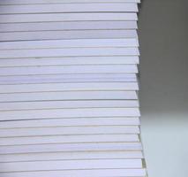 Stacks of books with white paper isolated on background. Office or student school high workload themed photo. photo