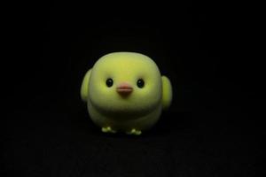 Chicken toy pet cute miniature kids toy isolated on dark black background. photo