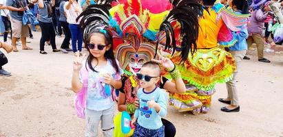 Loei, Thailand-July 26, 2022 Phi Ta Khon or Ghost festival. Children taking photo with local people wearing colorful clothing and mask for celebrated culture or traditional on July of every year.