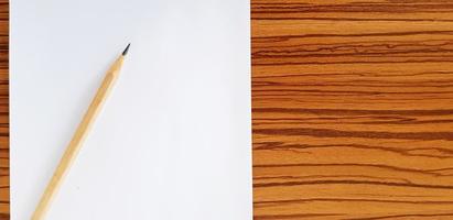 Brown pencil with white paper putting on wooden table with copy space for fill text. Education, Document and Object concept photo