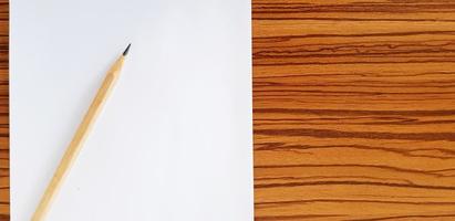 Brown pencil with white paper putting on wooden table with copy space for fill text. Education, Document and Object concept photo