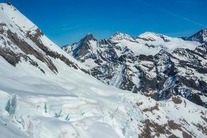 Magica view of the Alps mountains in Switzerland. View from helicopter in Swiss Alps. Mountain tops in snow. Breathtaking view of Jungfraujoch and the UNESCO World Heritage - the Aletsch Glacier photo