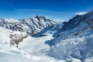 Magica view of the Alps mountains in Switzerland. View from helicopter in Swiss Alps. Mountain tops in snow. Breathtaking view of Jungfraujoch and the UNESCO World Heritage - the Aletsch Glacier photo