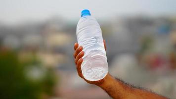 agua botella en el mano foto