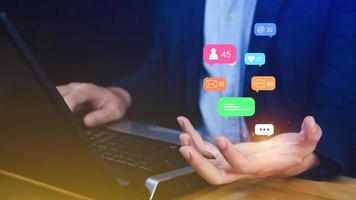 People using social media and digital online marketing concepts on laptop with icons such as notifications, messages, comments on the smartphone screen. photo