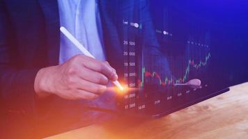 Businessman stylus pen touch points symbol stock graph and chart background, concept growth and development business investment, Stock market and strategy making market plan photo