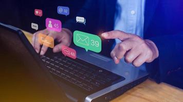 People using social media and digital online marketing concepts on laptop with icons such as notifications, messages, comments on the smartphone screen. photo