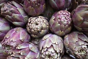 Stack of artichokes on a market stall photo