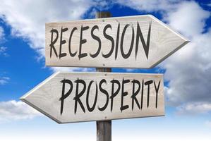 Prosperity, Recession - Wooden Signpost with Two Arrows and Cloudy Sky in Background photo