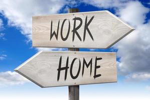 Home, Work - Wooden Signpost with Two Arrows and Cloudy Sky in Background photo