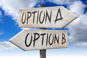 Option A, Option B - Wooden Signpost with Two Arrows and Cloudy Sky in Background photo