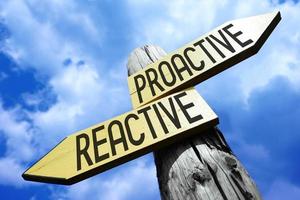 Proactive, Reactive - Wooden Signpost with Two Arrows and Sky in Background photo