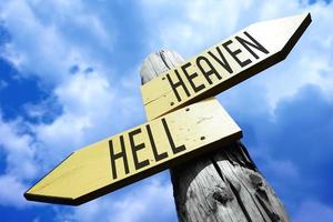 Heaven, Hell - Wooden Signpost with Two Arrows and Sky in Background photo