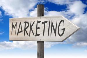 Marketing - Wooden Signpost with one Arrow and Cloudy Sky in Background photo