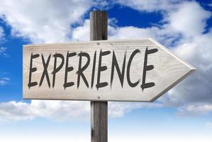 Experience - Wooden Signpost with one Arrow and Cloudy Sky in Background photo